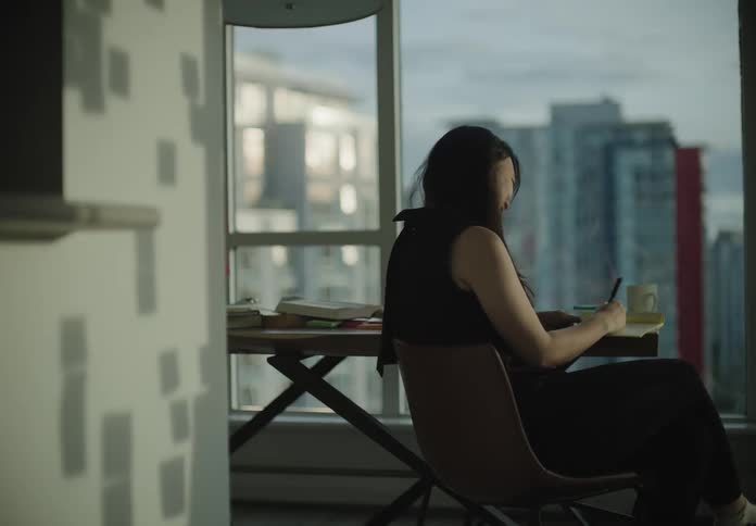 A woman sitting at a desk in broad daylight
