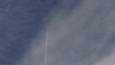Trails from a plane can be seen in a cloudy sky