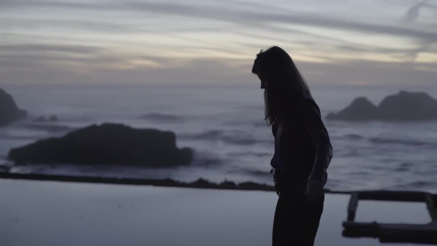 A woman walks slowly at sunset
