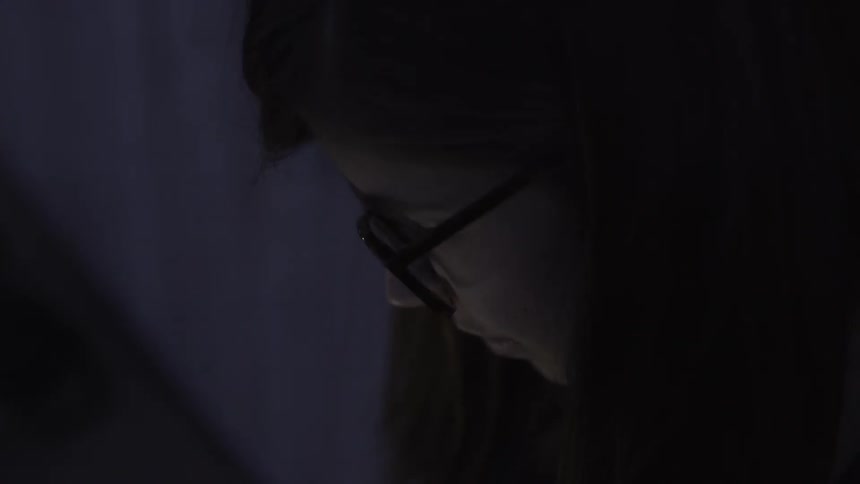 A person is looking down in a dark area