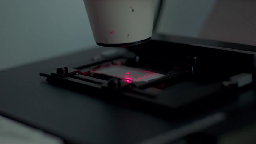 A microscope lights up a glass slide in a laboratory