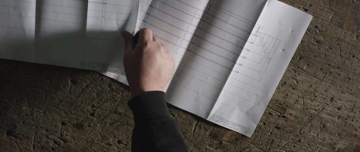 A white person sets down papers and smooths them out