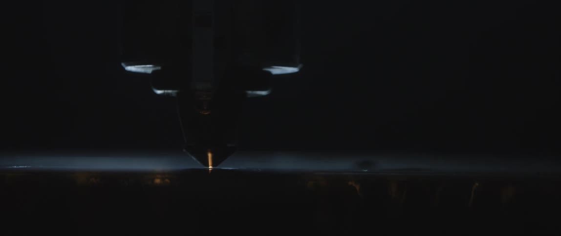 A machine moves and strikes sparks on an object