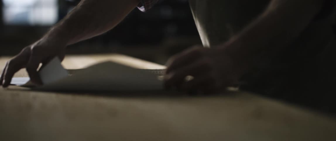 A person placing sheets of paper on a table