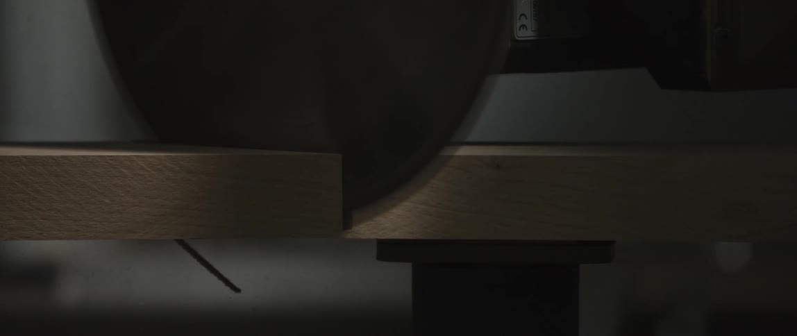 A table saw cuts a piece of wood