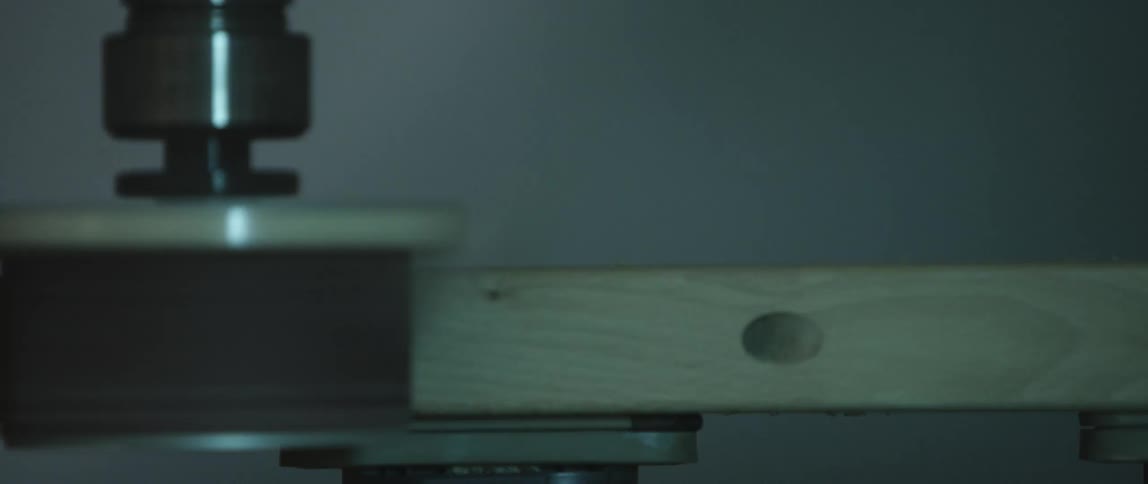 A lathe sands the side of a board