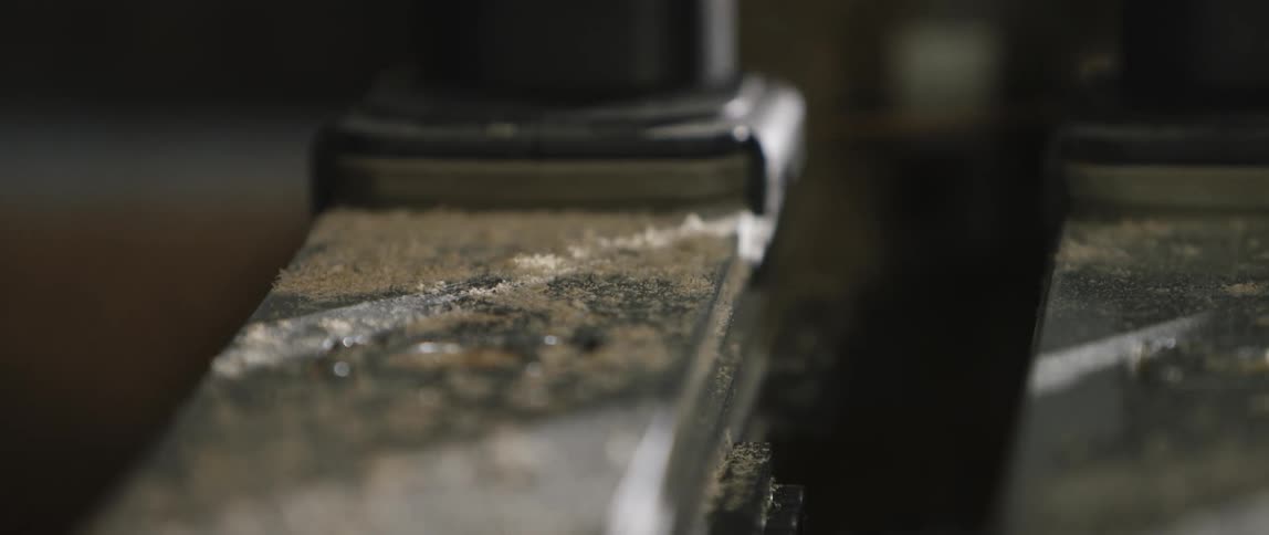Sawdust covers a board on a workbench