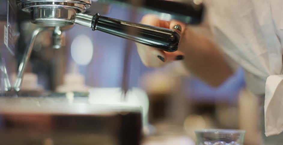 A woman in a coffee shop makes a drink