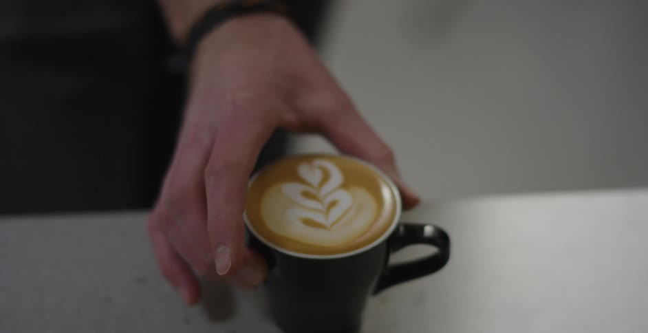 Man puts a cup of latte on the counter