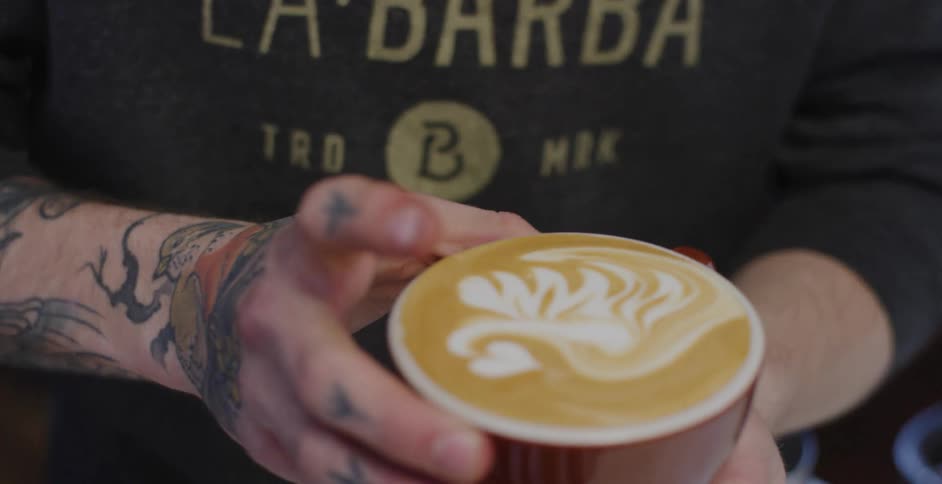 Man pours coffee into a cup and puts it on the table