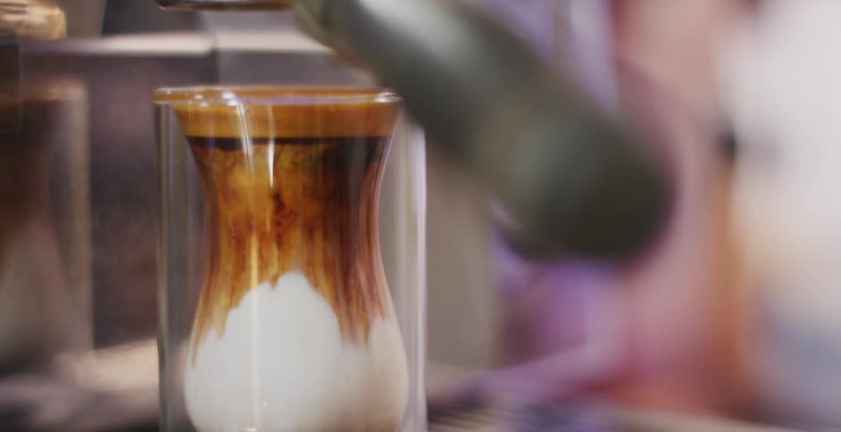 A white male lifts a cup of coffee out of a machine