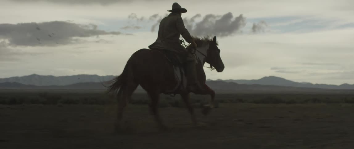 A man rides horseback in a rural setting