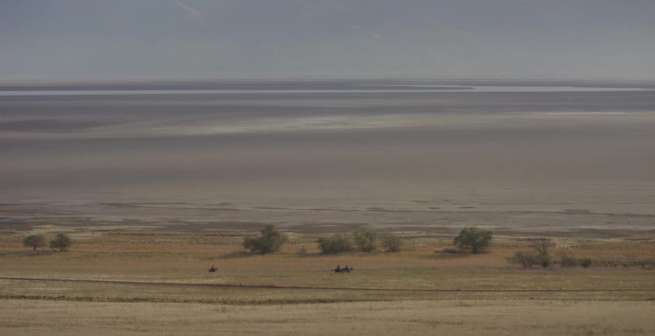People ride horses at a distance