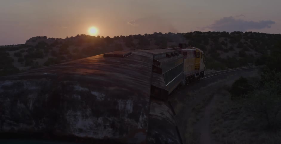 A train traveling on rail with the sky in the background