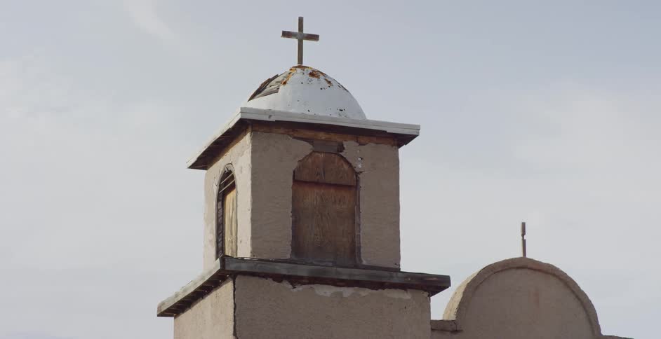 A dome with a cross on top sits on a church