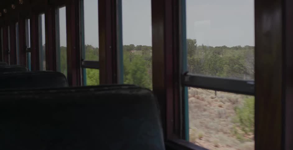 Desert terrain move by the window of a train car