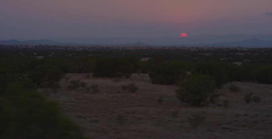 Scrub fills a desert area with mountains in the background
