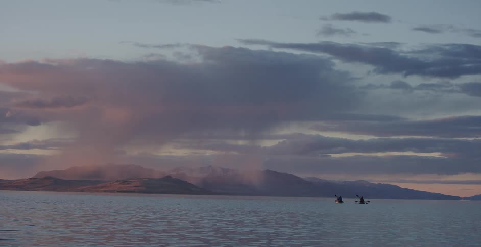 Kayaks on the calm waters of a lake at sunset