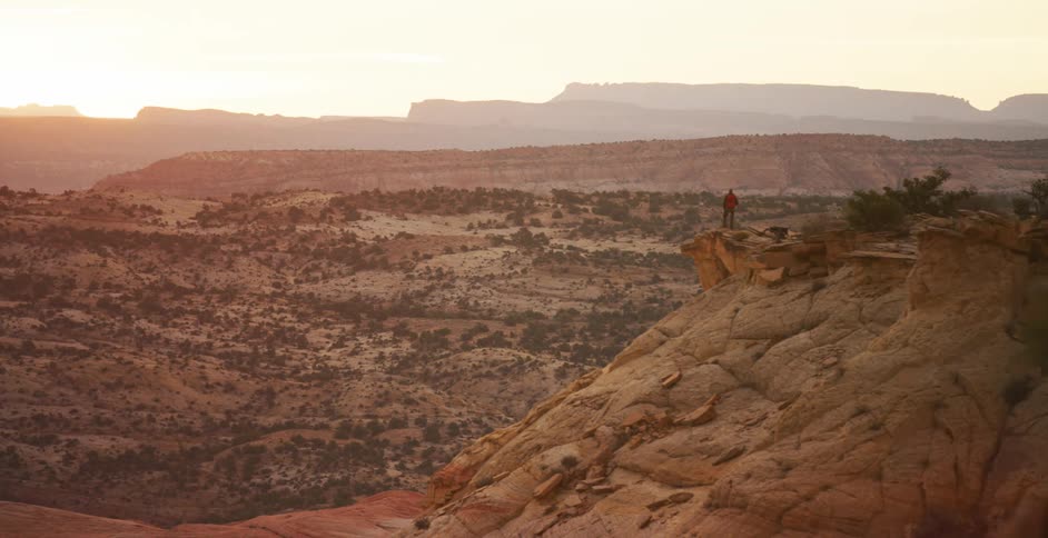 A man hiking on a cliff with a dog