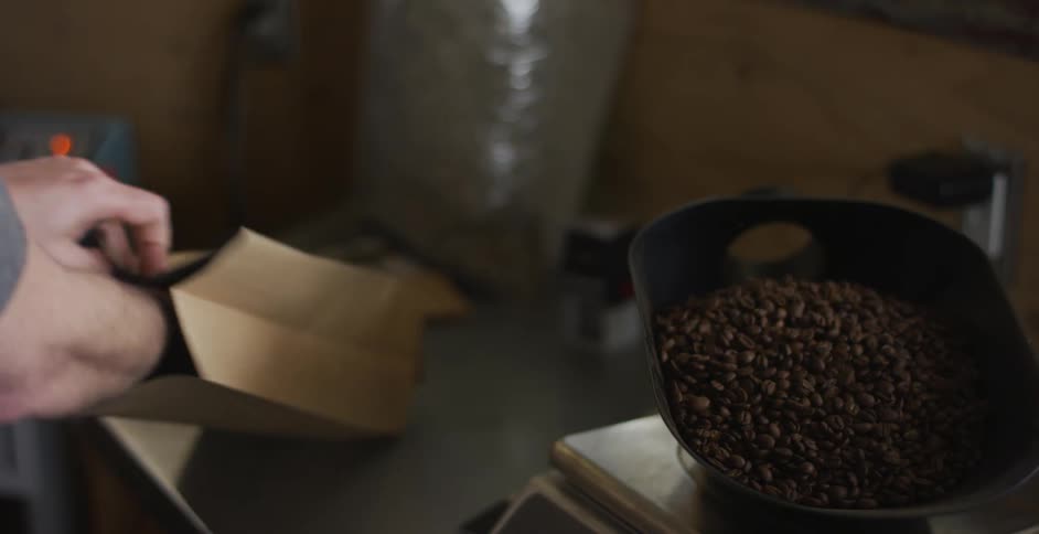 An employee weighs coffee beansand puts them in a paper bag