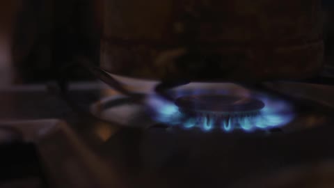 A man lights a match to start a burner