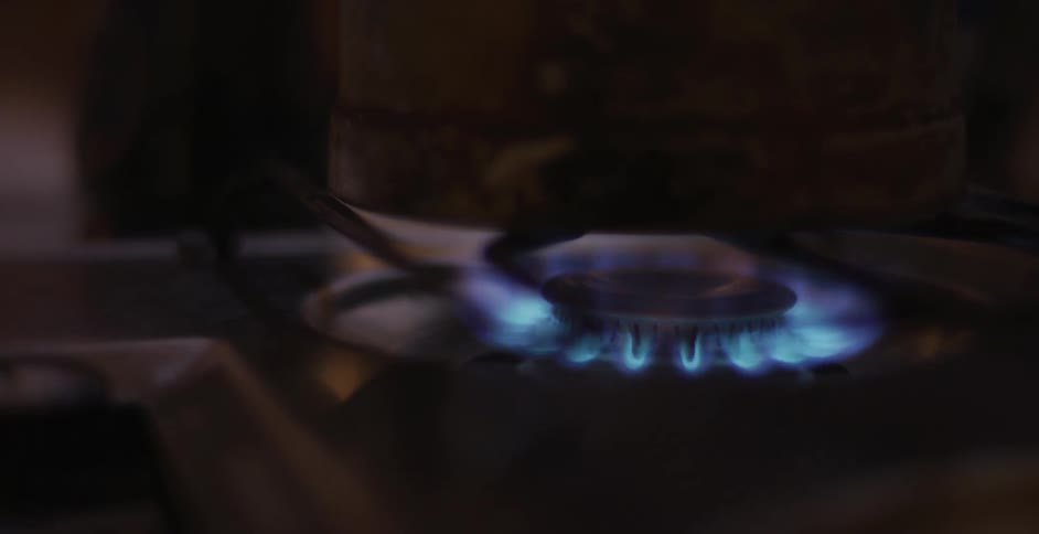 A man lights a match to start a burner