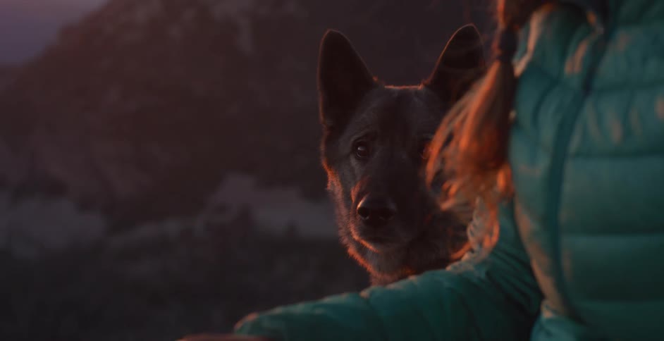 A woman sits beside her dog outside