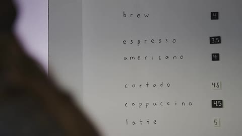A person is looking at a menu on a wall