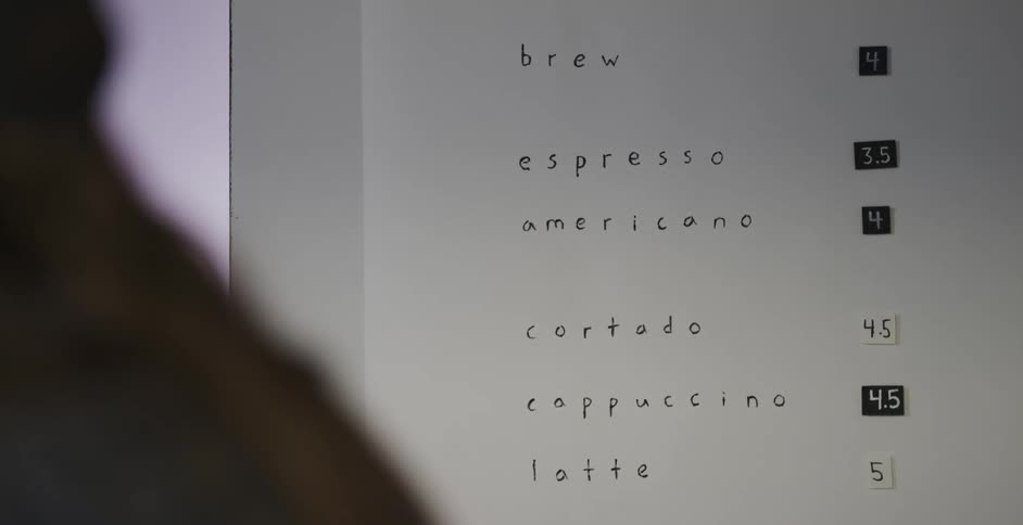 A person is looking at a menu on a wall