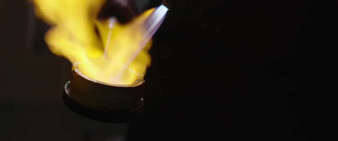 Man uses a torch to melt metal in a crucible 5