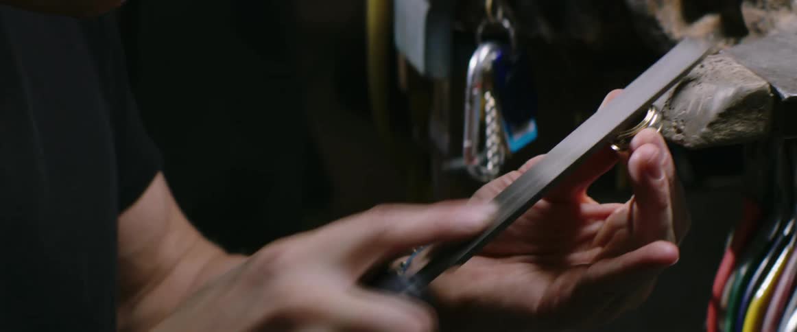 Jeweler files ring on workbench using a metal file