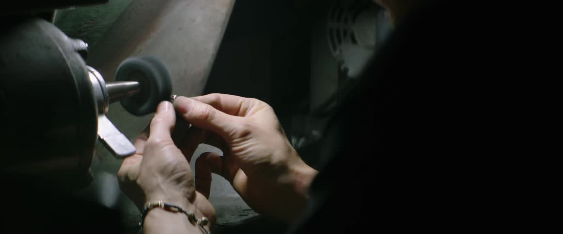 A jeweler shines a diamond ring