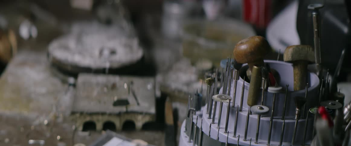 Electric power tool bits organized in container on dust covered workbench