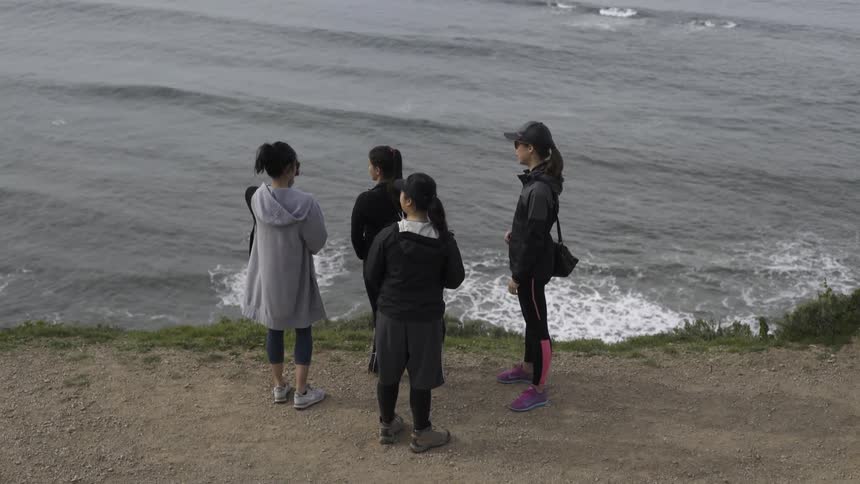 A group of women stand near a body of water