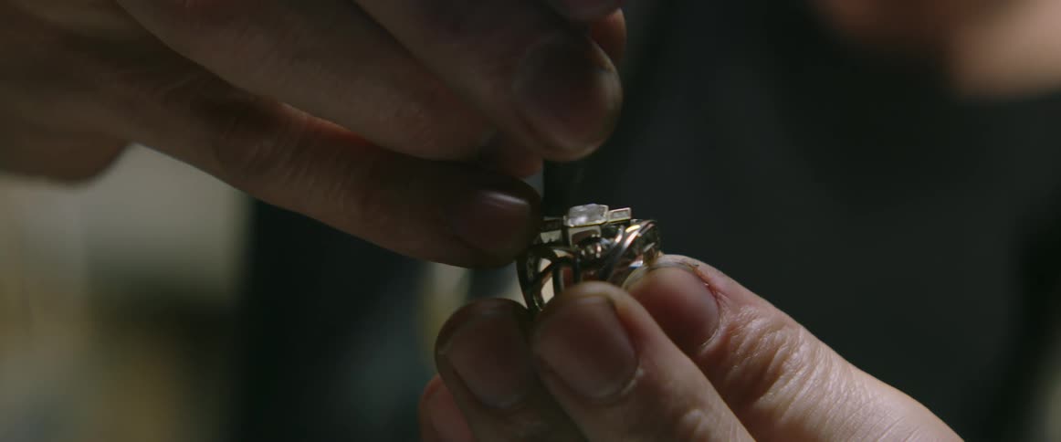 The person adds a diamond to the ring