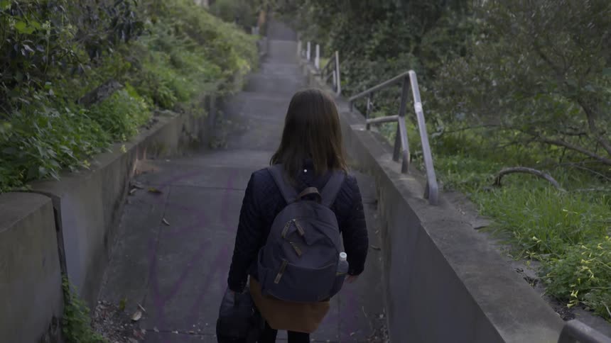 A woman is traveling down stone steps