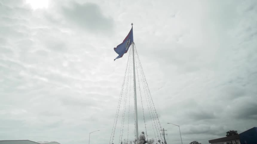 A flag blows in the wind as it flies from the mast of a boat