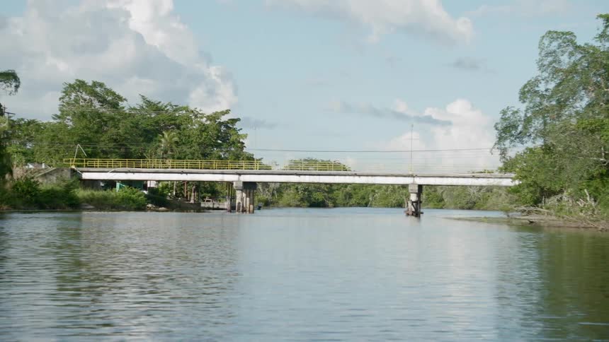 A bridge with yellow railing over a river during the day