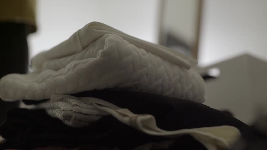 A person folds clothing and stacks it