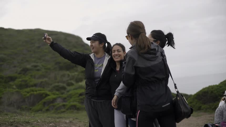 A group of people are posing for a photograph on a cloudy day
