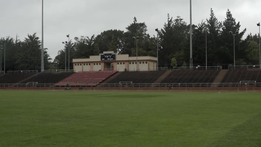 People running around football field track together with energetic athletic teamwork vibe.