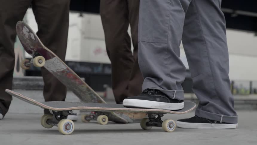 People are standing together with skateboards by their feet