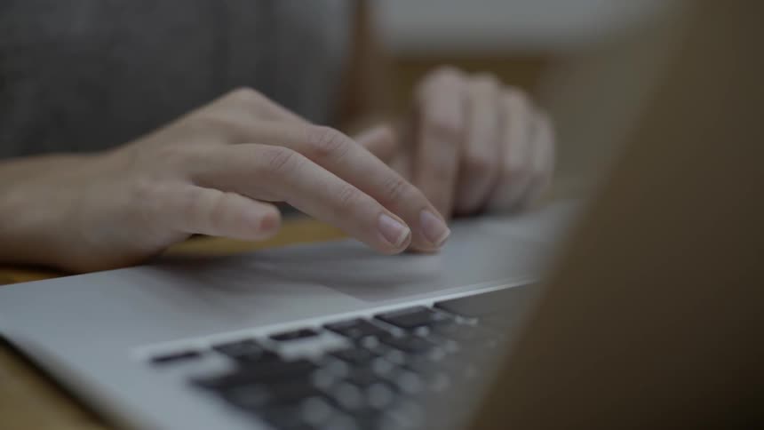 A person is typing on a laptop on a desk
