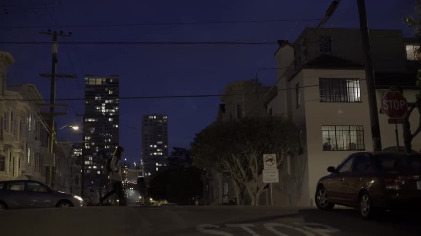 Person walking alone down city street at night with moody reflective vibe.