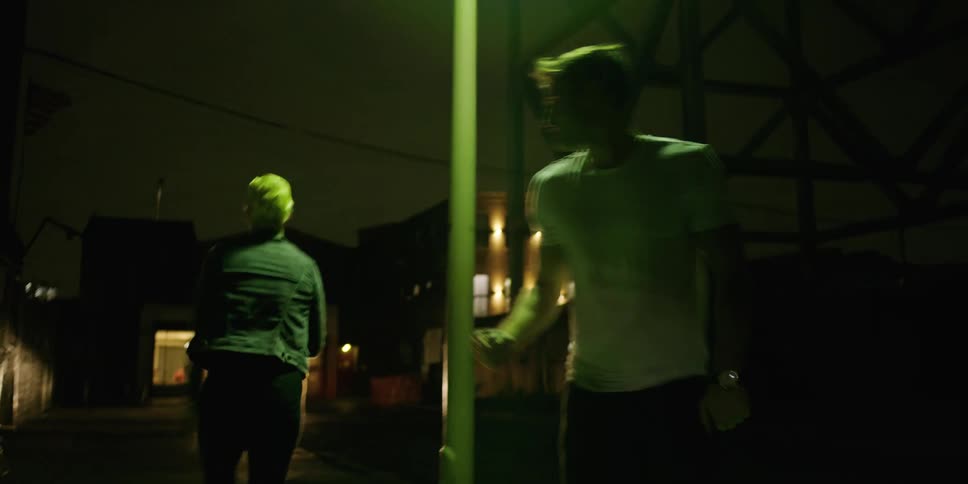 A man and woman are dancing outdoors at night