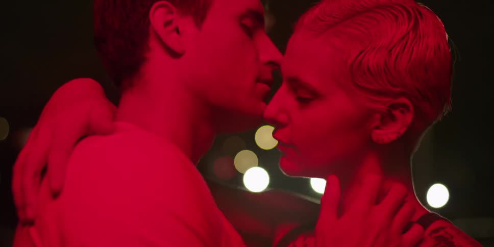 A man and woman kiss as they embrace
