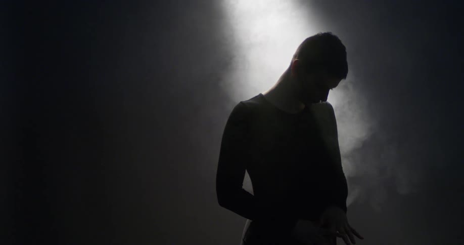 A light shining down on a person with their hands and fingers splayed also highlights steam surrounding them