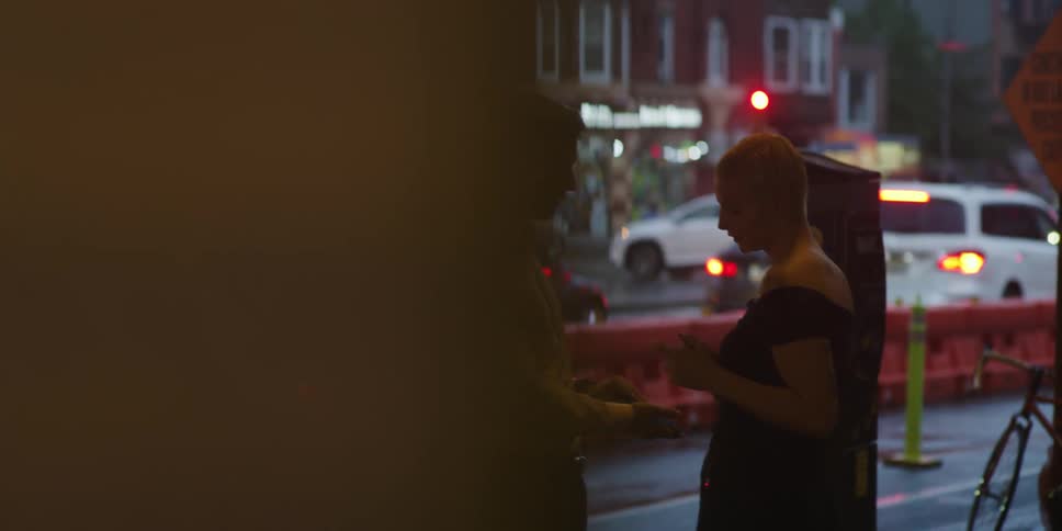 Couple talks near traffic barrier separating pedestrians from traffic