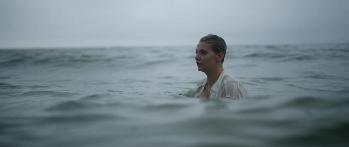 A woman with a shirt standing in water up to her shoulders
