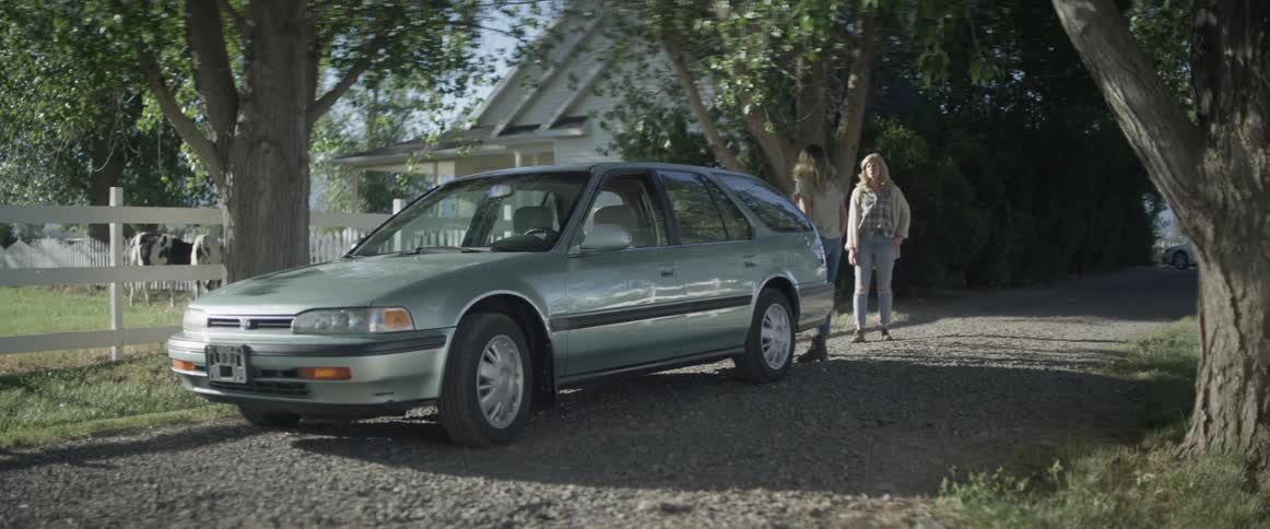 A girl closes her car trunk and then her and her mother hug